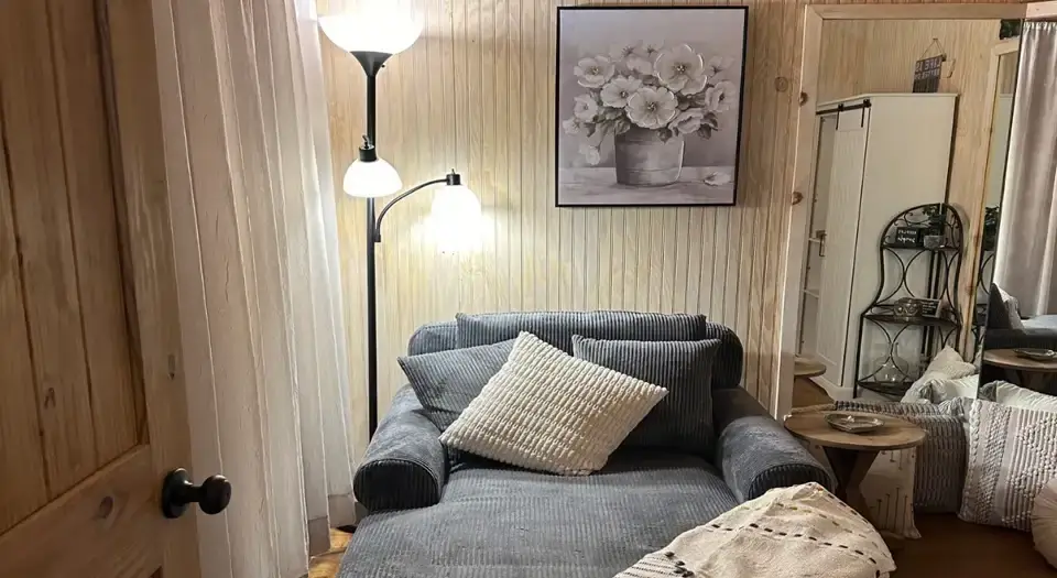 View of a seating area, featuring a chaise lounge, inside the cabin at Eureka Springs Riverview Oasis